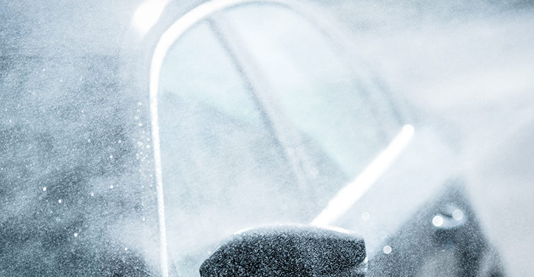 Gentle Car Washing. Modern Compact Car Covered by Water. Dark Blue Color Grading.